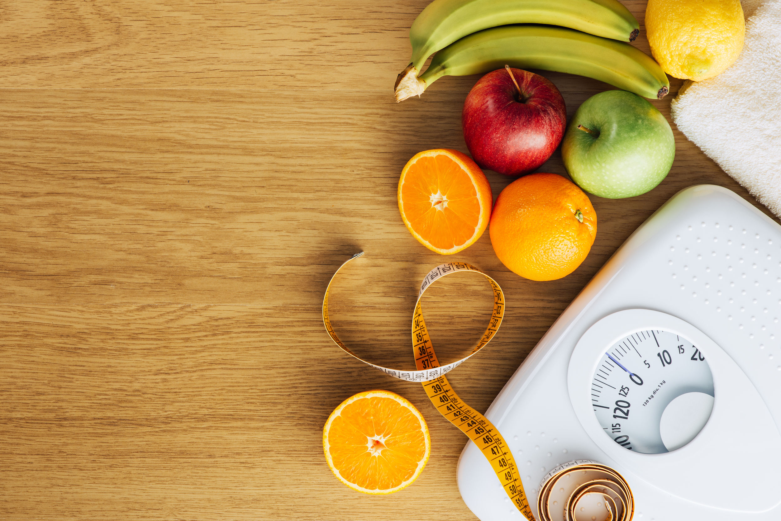 White scale with fruit on a wooden table